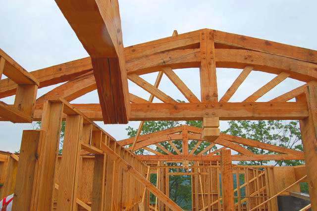 timber frame roof trusses designed by Rand Soellner Architect in log home under construction.